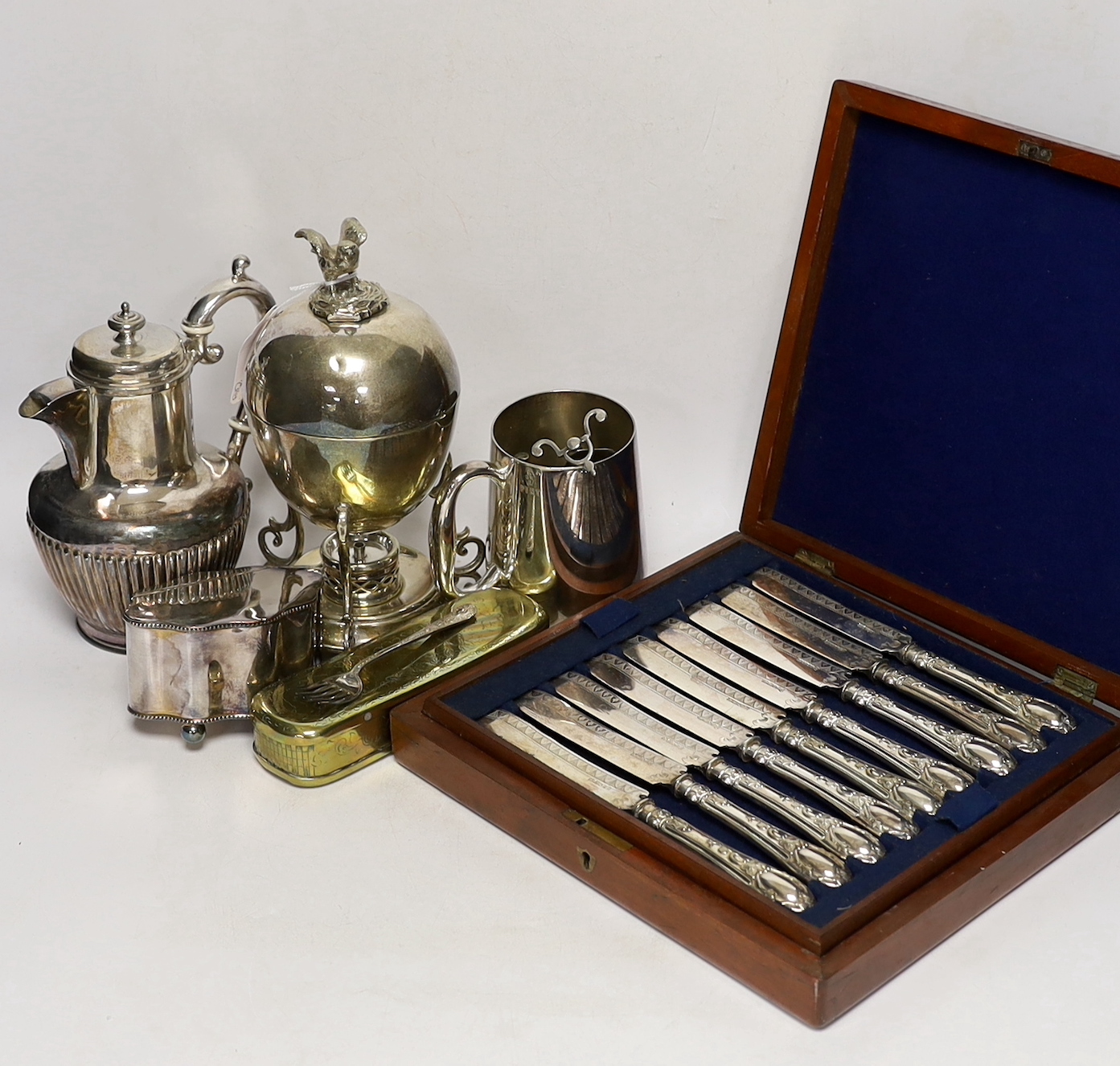 Assorted plated ware including a cased set of dessert knives, egg coddler, caddy, mug etc.